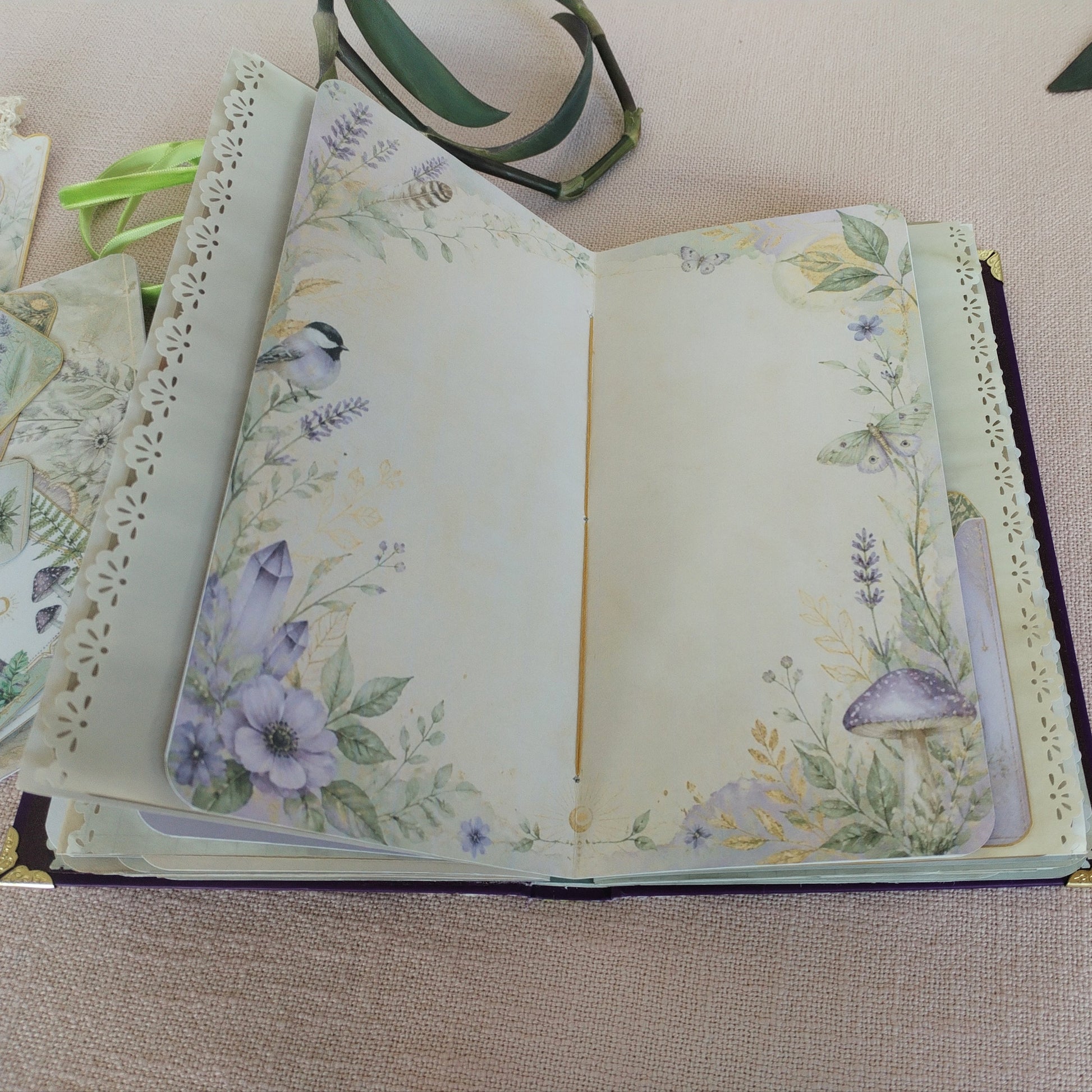 Journal Lila-Grün Innenseite Motivpapier in Lila- und Grüntönen mit Blumen, Vogel, Pilz und Kristallen