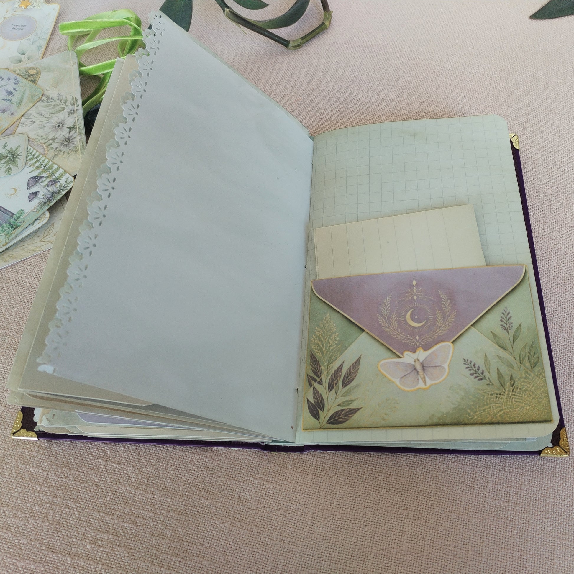 Journal Lila-Grün, Innenseite mit Papiertasche in Briefumschlag-Form, die ein kleines Schreibpapier enthält