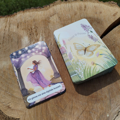 Karte 'Ich gönn mir eine digitale Auszeit' aus dem Kartendeck Pause und Power. Eine Frau, die fröhlich und beschwingt, unter einer Lichterketten geschmückten Brücke geht. Produktbild 1. 